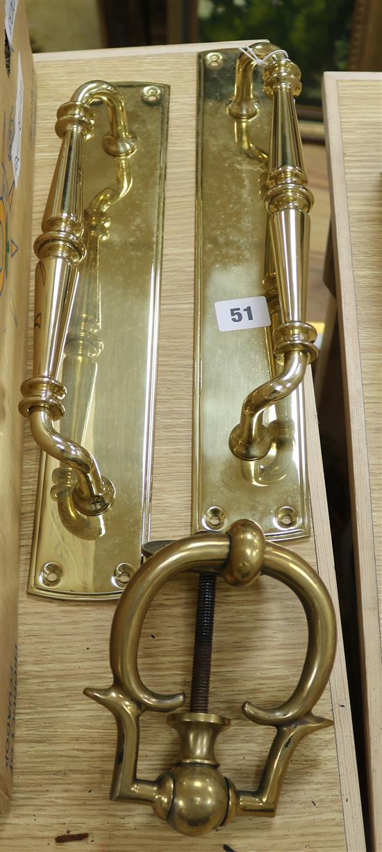 Two brass door pulls and a door knocker